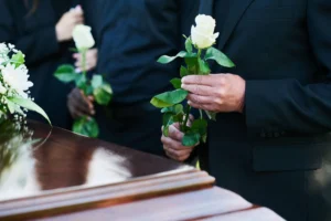 213173585_l-1920w - Insider Accident Lawyers - Insider Accident Lawyers Mourners laying white roses on a coffin.