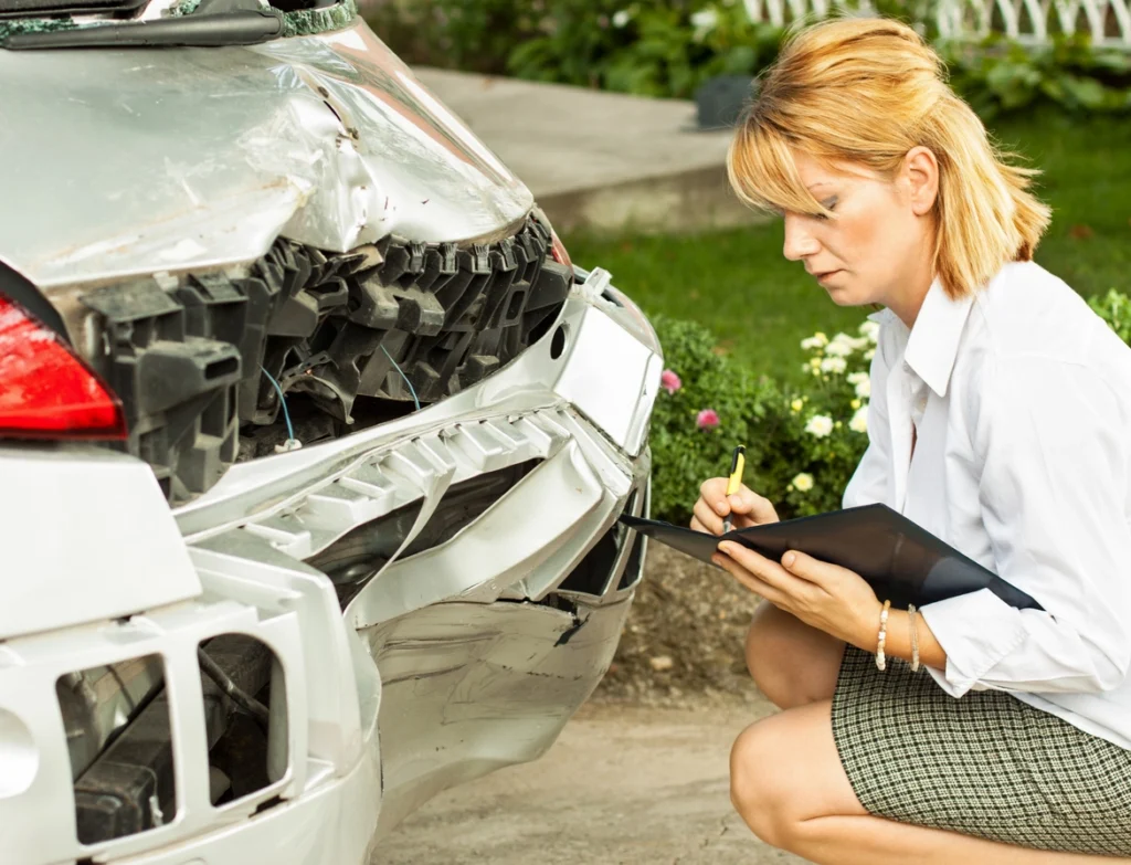 Accident Reconstruction - kajakiki - Insider Accident Lawyers An accident reconstruction expert examining the damage to a car after an accident.