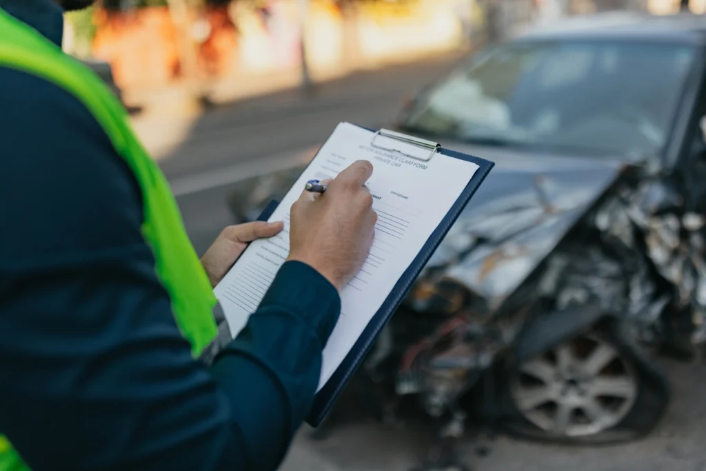 An accident reconstruction expert examining a damaged vehicle.