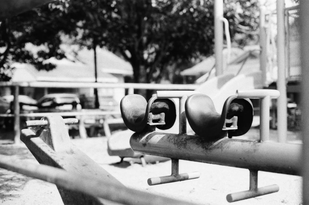 An empty run-down playground depicted in black and white.