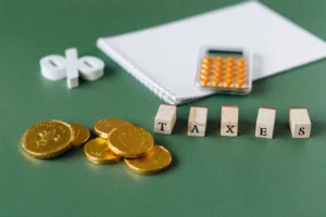 Taxes | Insider Accident Lawyers - Insider Accident Lawyers - Insider Accident Lawyers A calculator, notepad, stack of coins, percentage symbol, and blocks spelling out "taxes" on a green table.