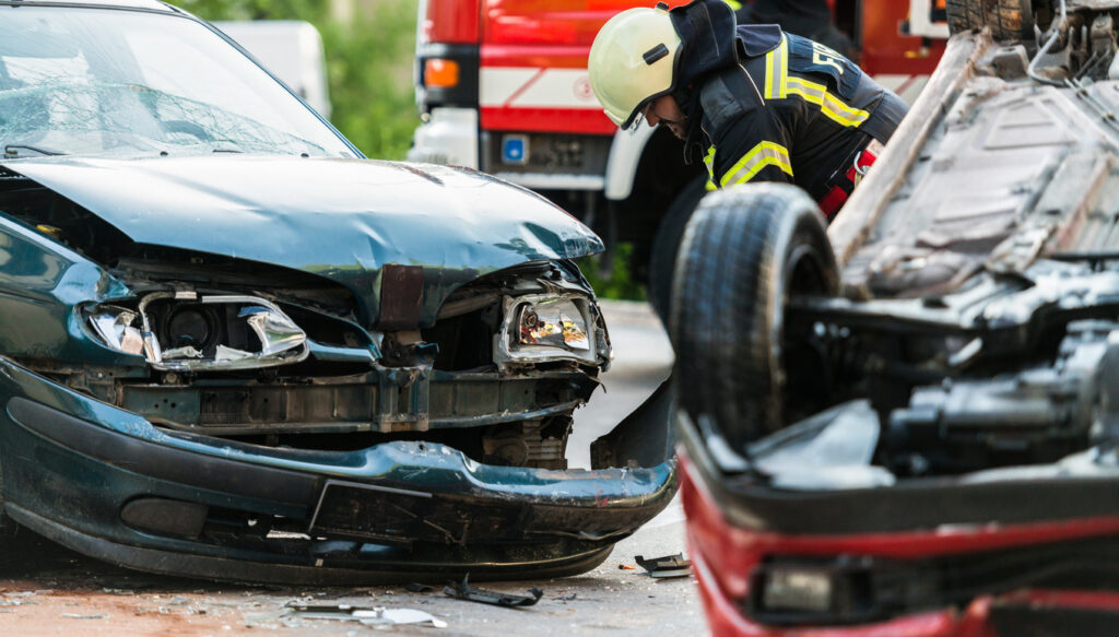 Firefighters At A Car Accident Scene - Insider Accident Lawyers Emergency services attending a car crash after an uninsured driver collision.