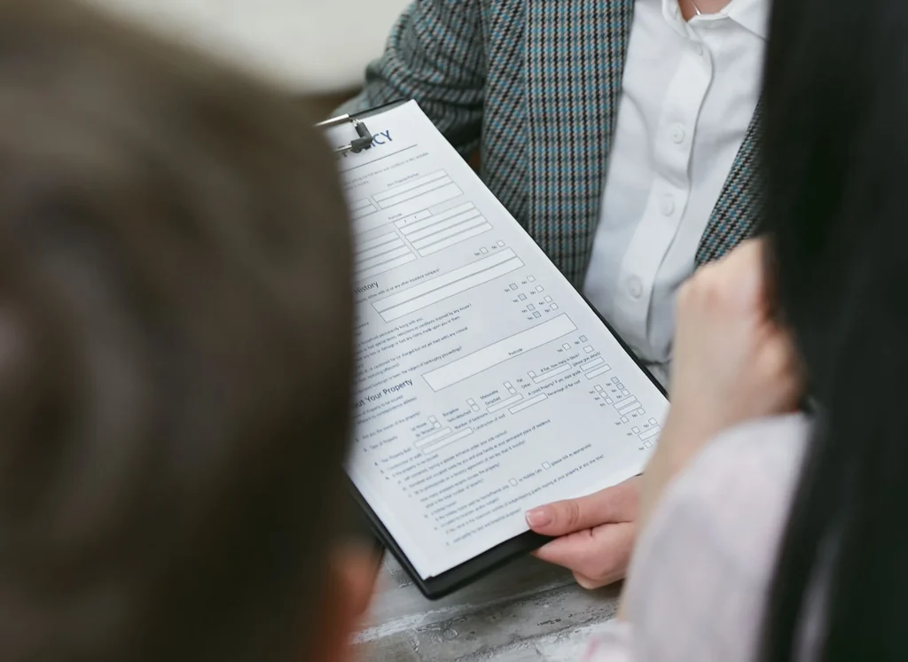 pexels-mikhail-nilov-7731329 - Insider Accident Lawyers A couple being influenced by insurance adjuster tricks as they're shown a document to sign.